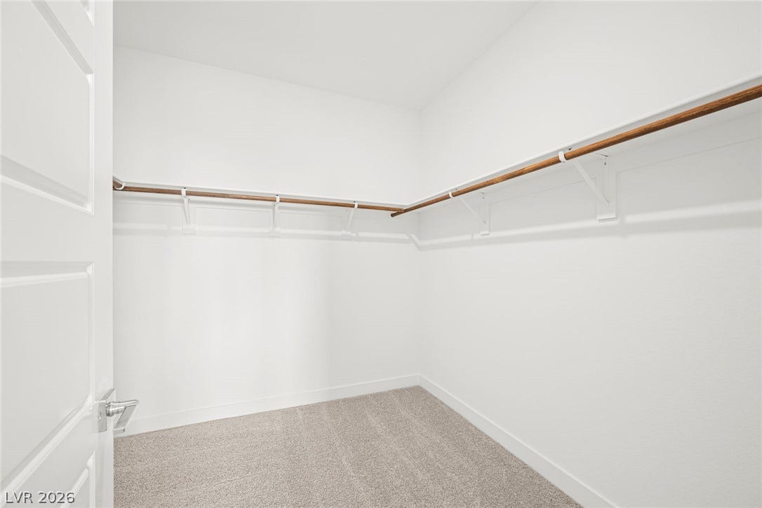 11823 Mimicking Song Lane, Las Vegas, NV 89138 Ample hanging space highlights this organized walk-in closet featuring neutral carpeting.