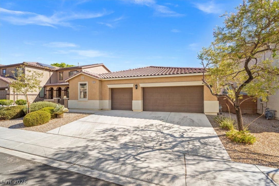 1874 Nature Park Drive, North Las Vegas, NV 89084 Stucco walls and a tiled roof define the exterior of this multi-car garage home.