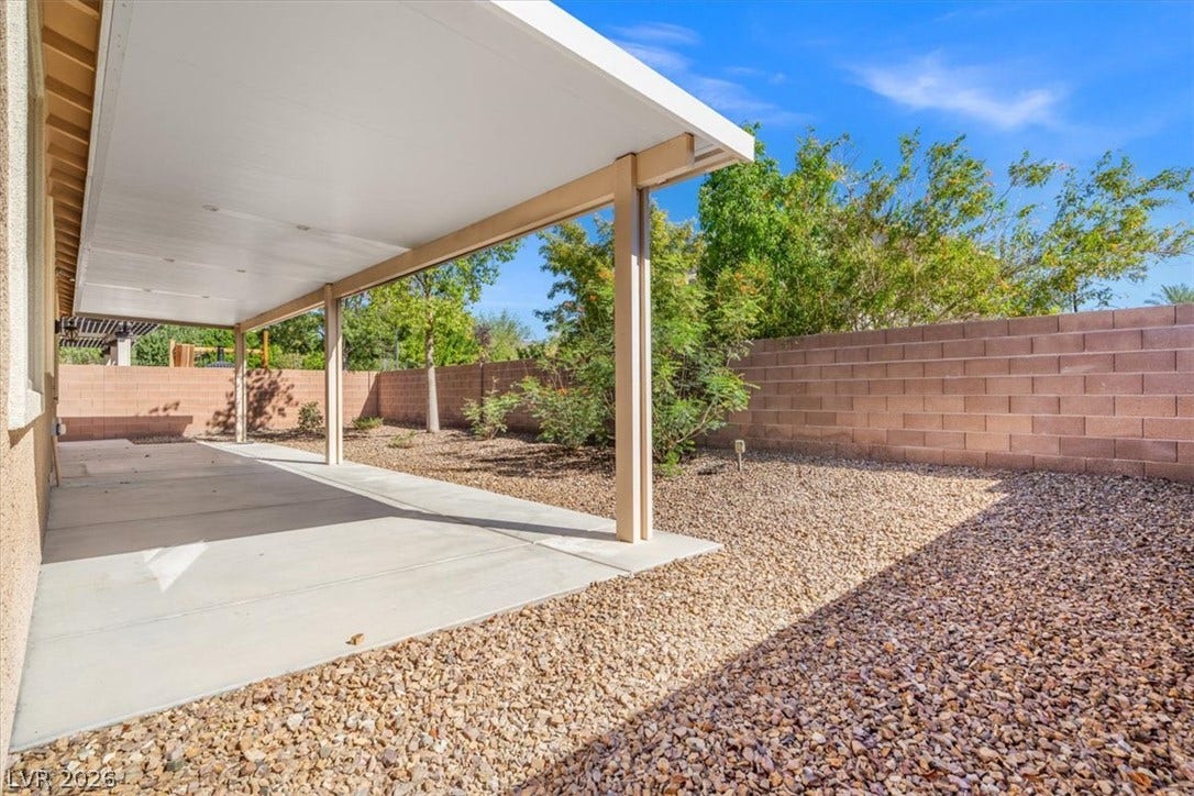 1874 Nature Park Drive, North Las Vegas, NV 89084 A spacious covered concrete patio overlooks a low-maintenance gravel yard enclosed by a block wall.