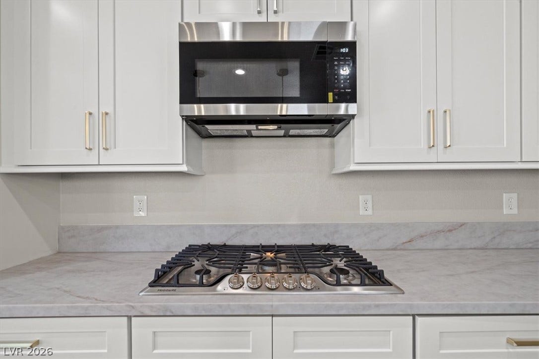 1874 Nature Park Drive, North Las Vegas, NV 89084 A modern gas cooktop integrates seamlessly with durable stone countertops and sleek cabinetry.