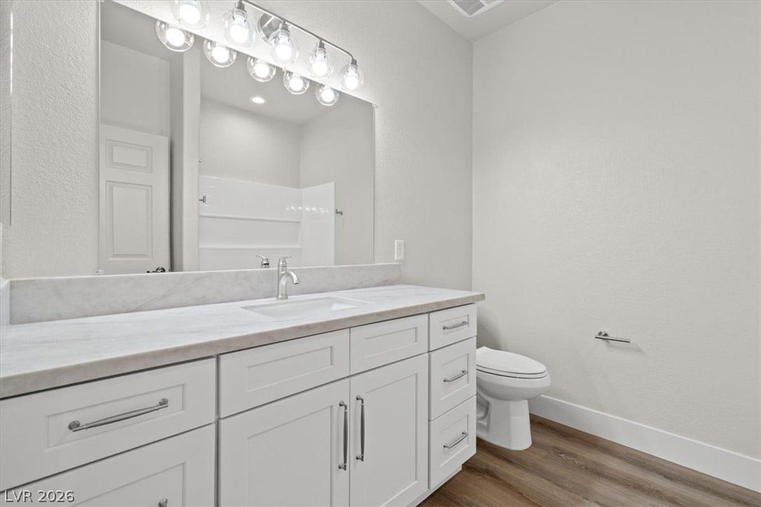 1874 Nature Park Drive, North Las Vegas, NV 89084 hall bath with smooth stone countertops pair with polished hardware over durable wood-look flooring.