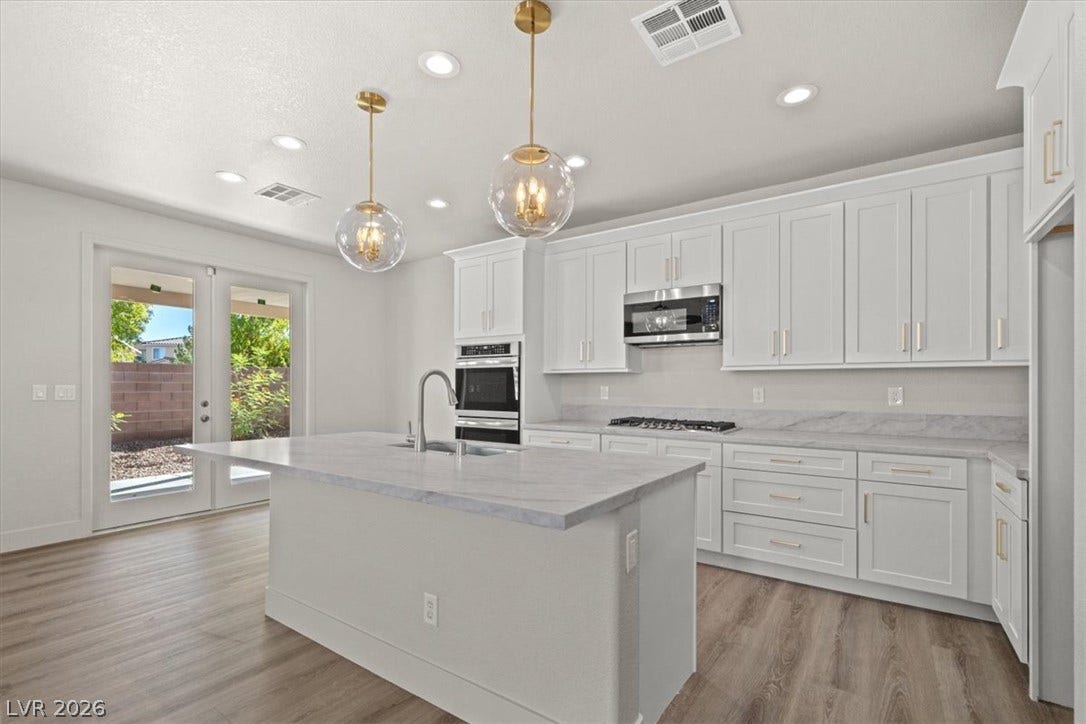 1874 Nature Park Drive, North Las Vegas, NV 89084 Recessed lighting, smooth stone countertops, and wood-look flooring anchor this airy cooking space.