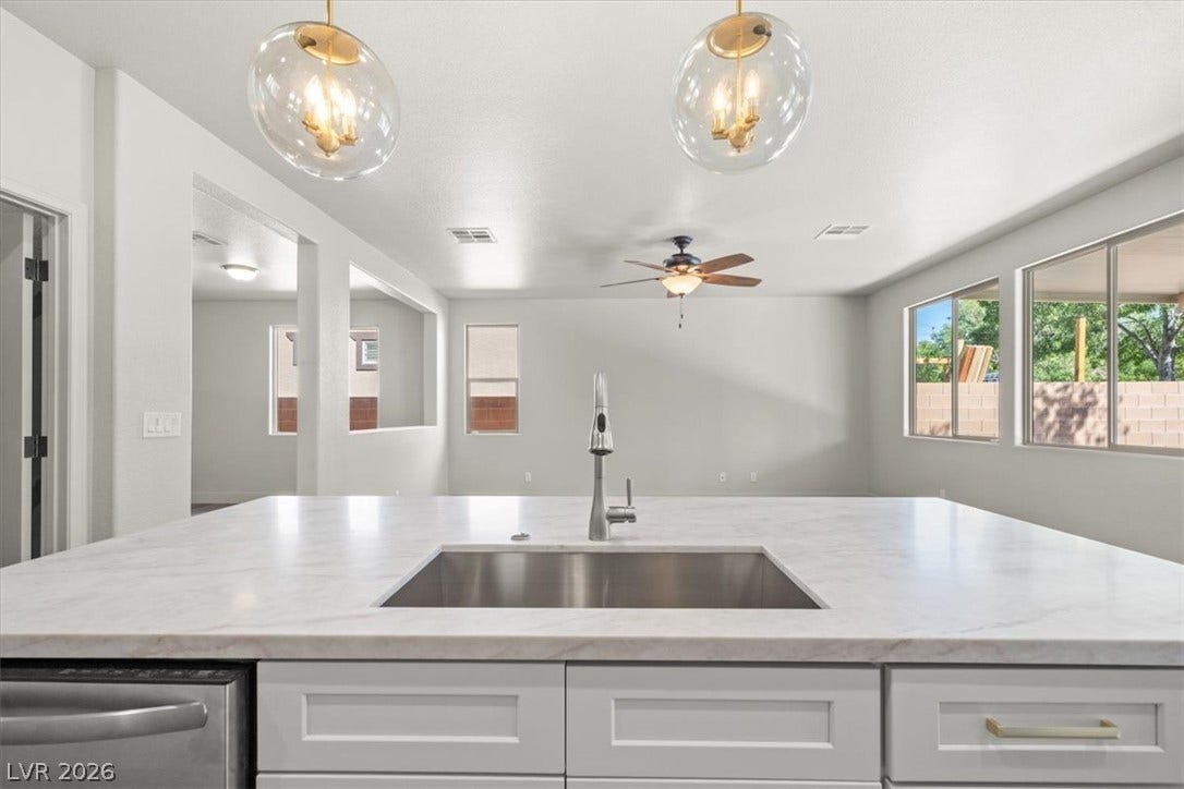 1874 Nature Park Drive, North Las Vegas, NV 89084 A spacious central island features stone countertops overlooking the adjacent open living area.