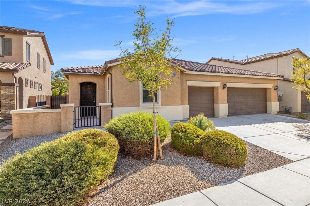 1874 Nature Park Drive, North Las Vegas, NV 89084 Spanish-style architecture highlights the exterior facade featuring a multi-car garage and low-maintenance desert landscaping.