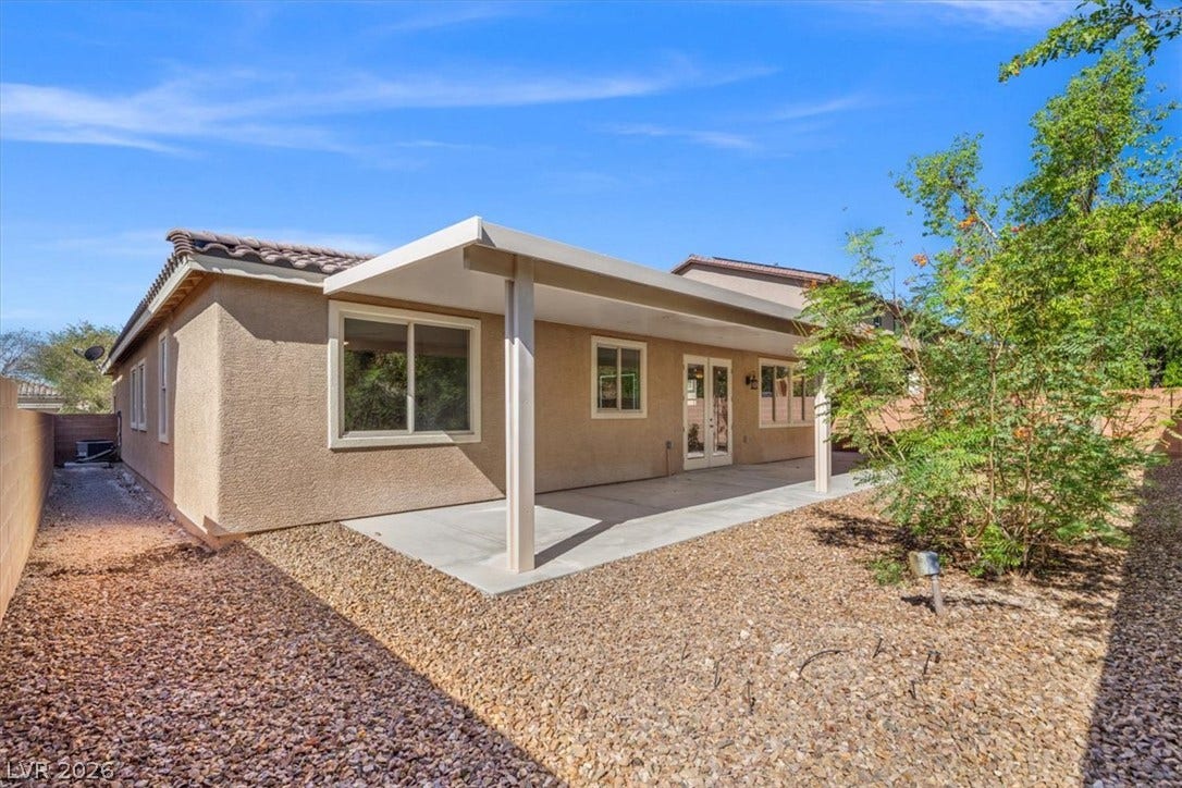 1874 Nature Park Drive, North Las Vegas, NV 89084 A spacious covered concrete patio extends from the stucco exterior, offering a shaded outdoor retreat.