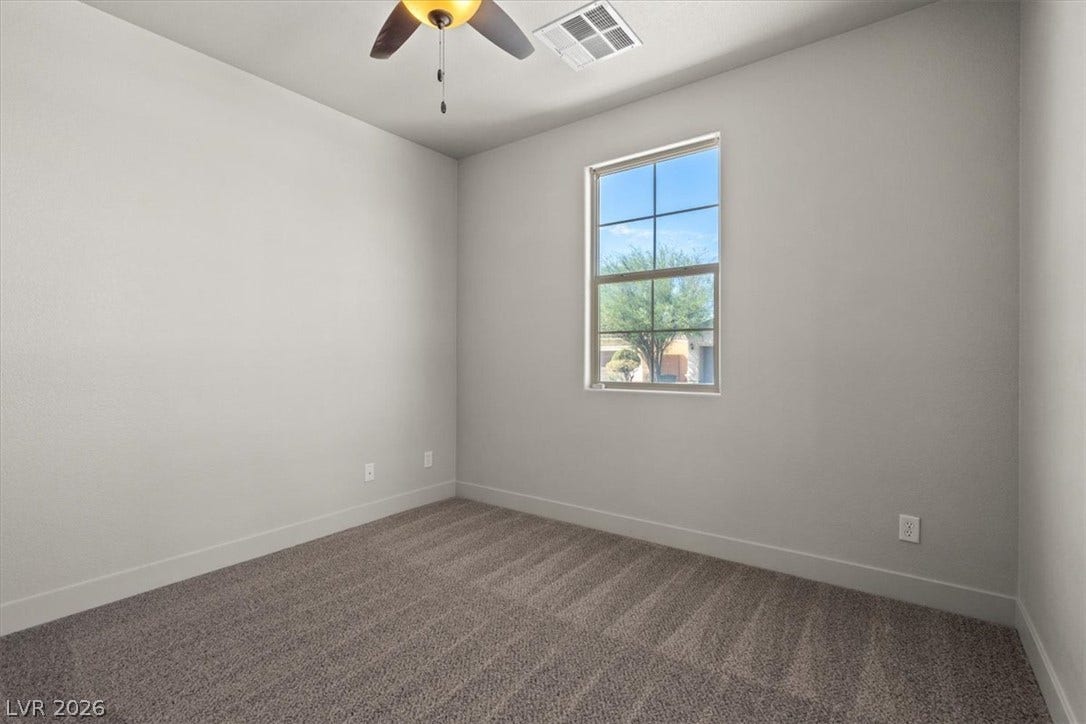 1874 Nature Park Drive, North Las Vegas, NV 89084 Soft carpeting pairs with neutral walls and a window overlooking the quiet outdoor scenery.