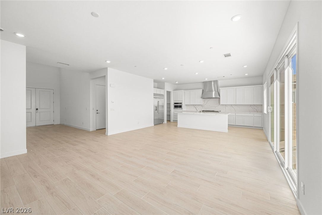 An open-concept living space with a modern kitchen and light wood flooring invites comfortable living.
