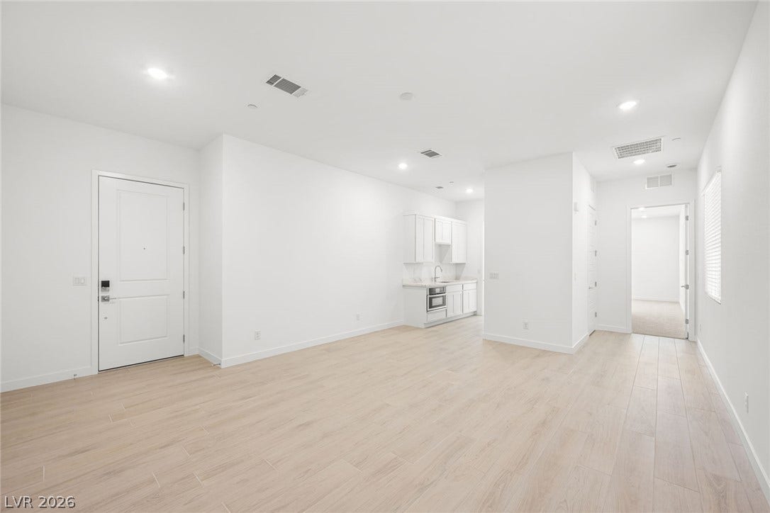 A spacious, airy room showcases durable tile flooring and a discreet wet bar for seamless entertaining.