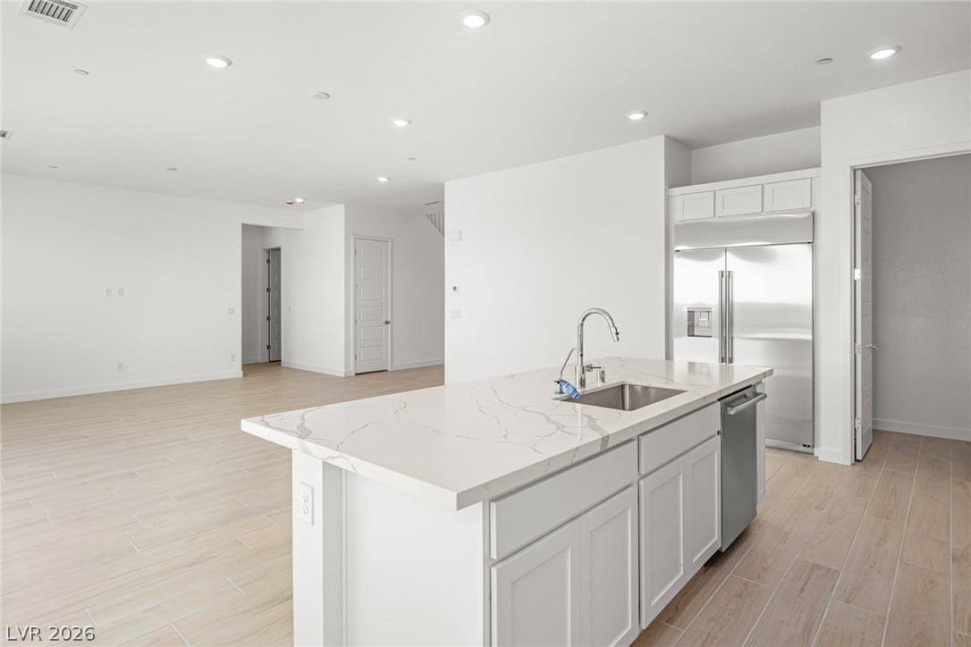 A well-lit kitchen island offers both prep space and a social hub, seamlessly connecting to the open living areas.