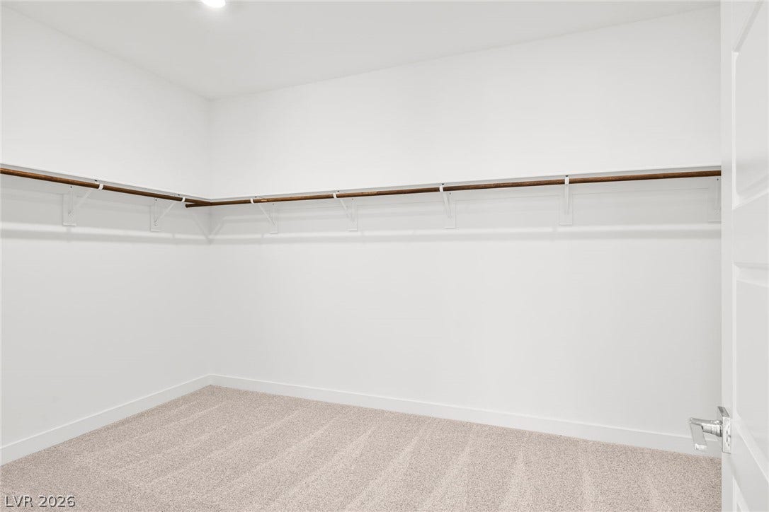 A spacious, neutral walk-in closet offers ample storage potential.