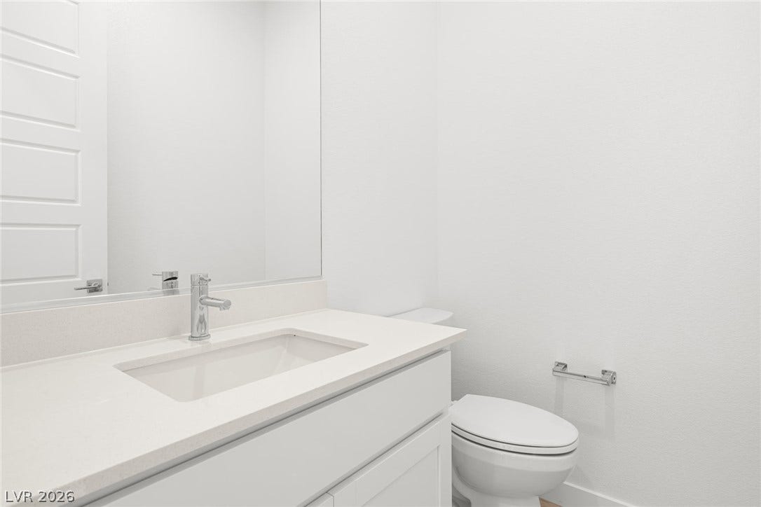 A well-lit powder room offers clean lines and a contemporary vanity with a gleaming faucet.
