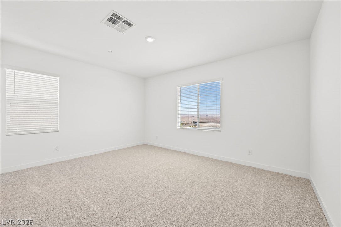 A well-proportioned bedroom with ample natural illumination and comfortable carpeting.