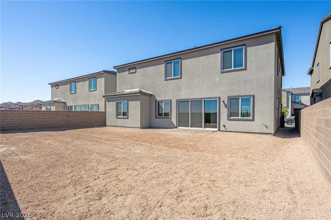 A spacious backyard awaits personalization, bordered by a privacy wall and offering desert mountain views.