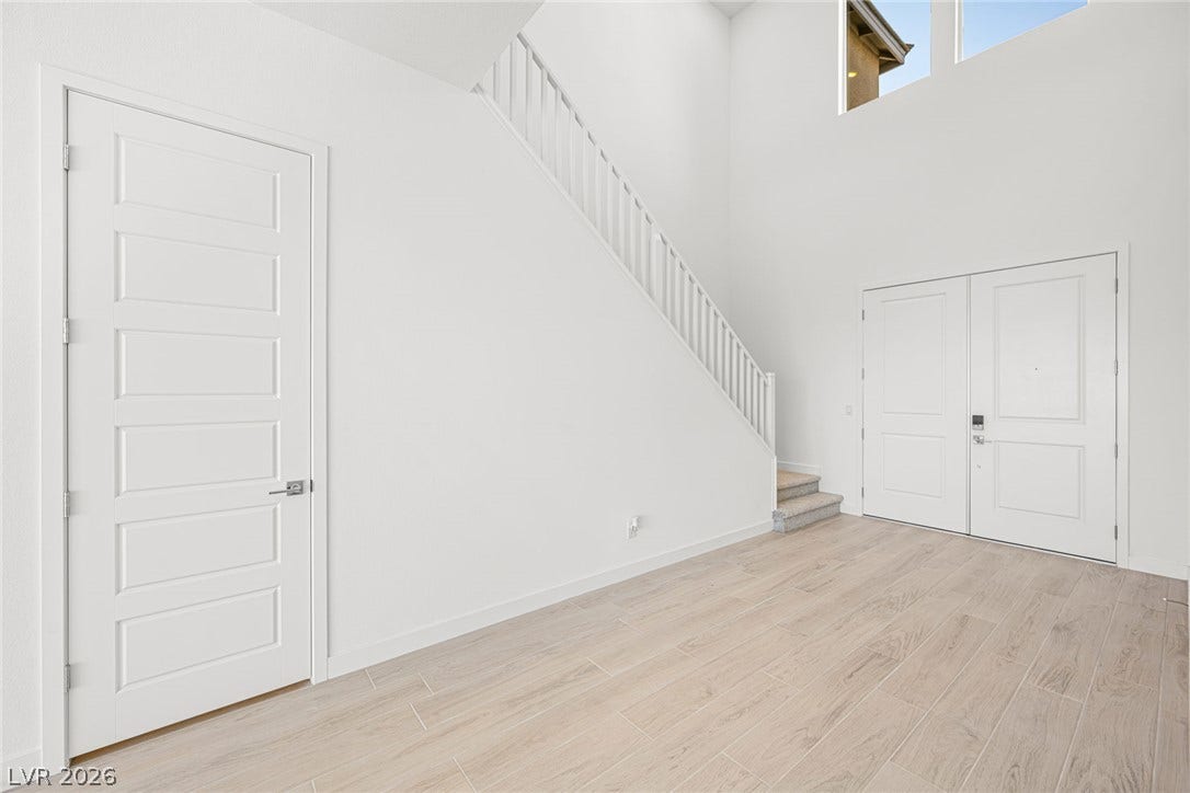 A grand entrance with soaring ceilings and light-toned flooring sets a welcoming tone.