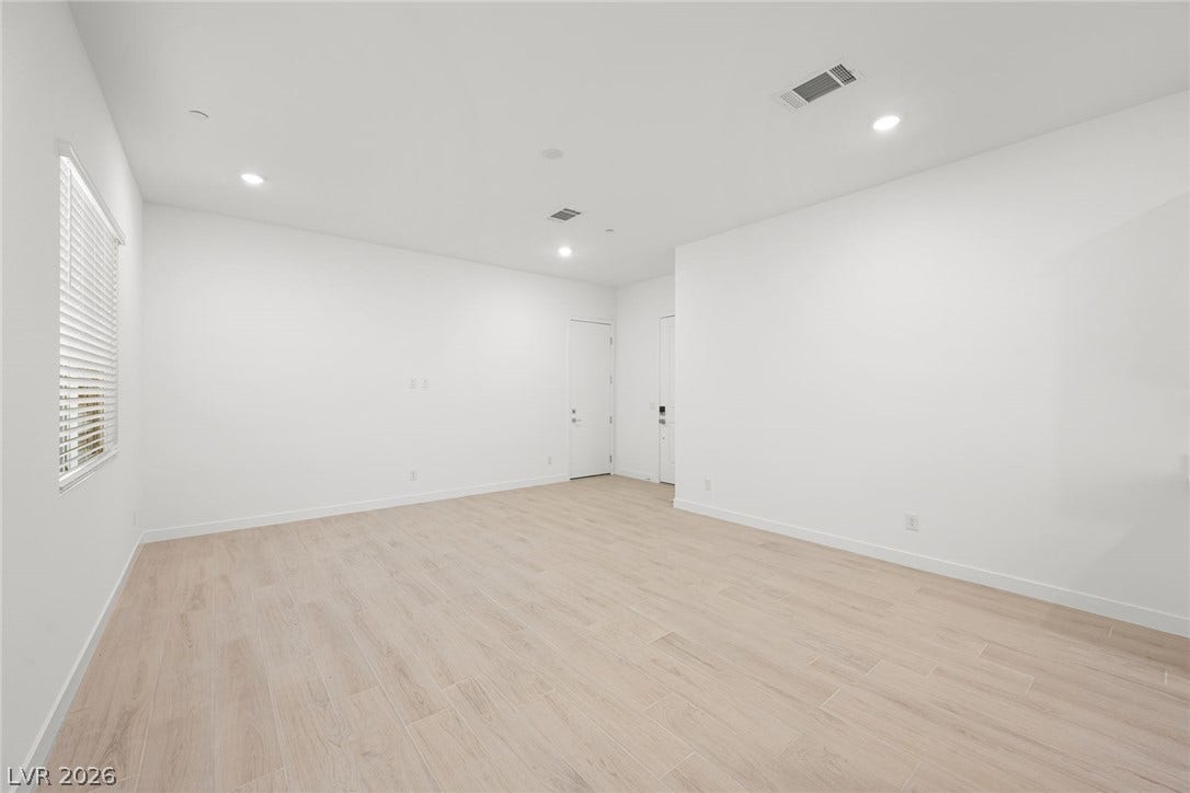 Recessed lighting illuminates an open-concept living space with neutral flooring, ready for personalized touches.