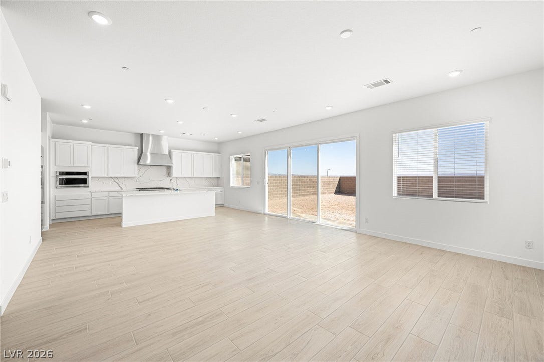 A spacious, open-concept interior features bright flooring and a sleek kitchen.