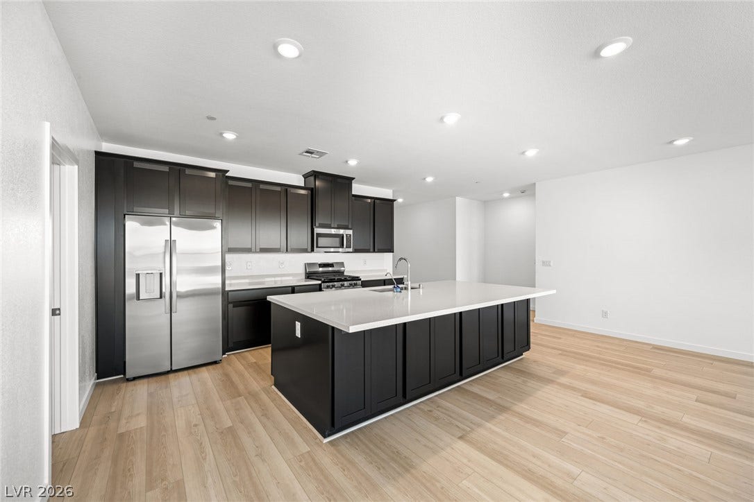 1663 Capri Falls Court, Henderson, NV 89011 An expansive central island anchors this contemporary culinary space featuring recessed lighting and wood-style flooring.