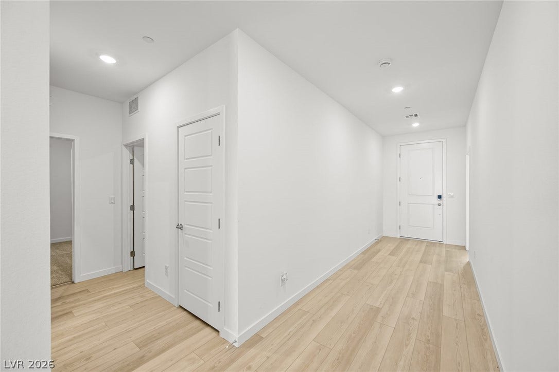 1663 Capri Falls Court, Henderson, NV 89011 Crisp white walls and light hardwood floors create an inviting entry hallway.