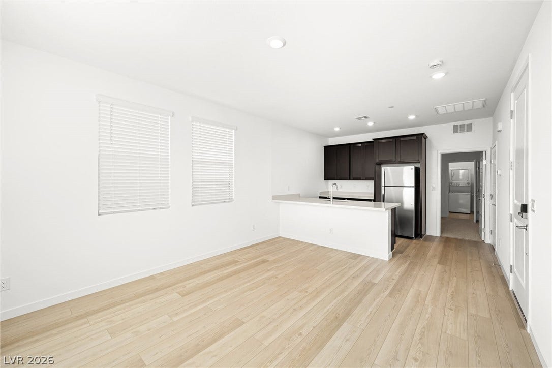1663 Capri Falls Court, Henderson, NV 89011 Clean lines and warm wood-style flooring define this open-concept main living space and kitchen.