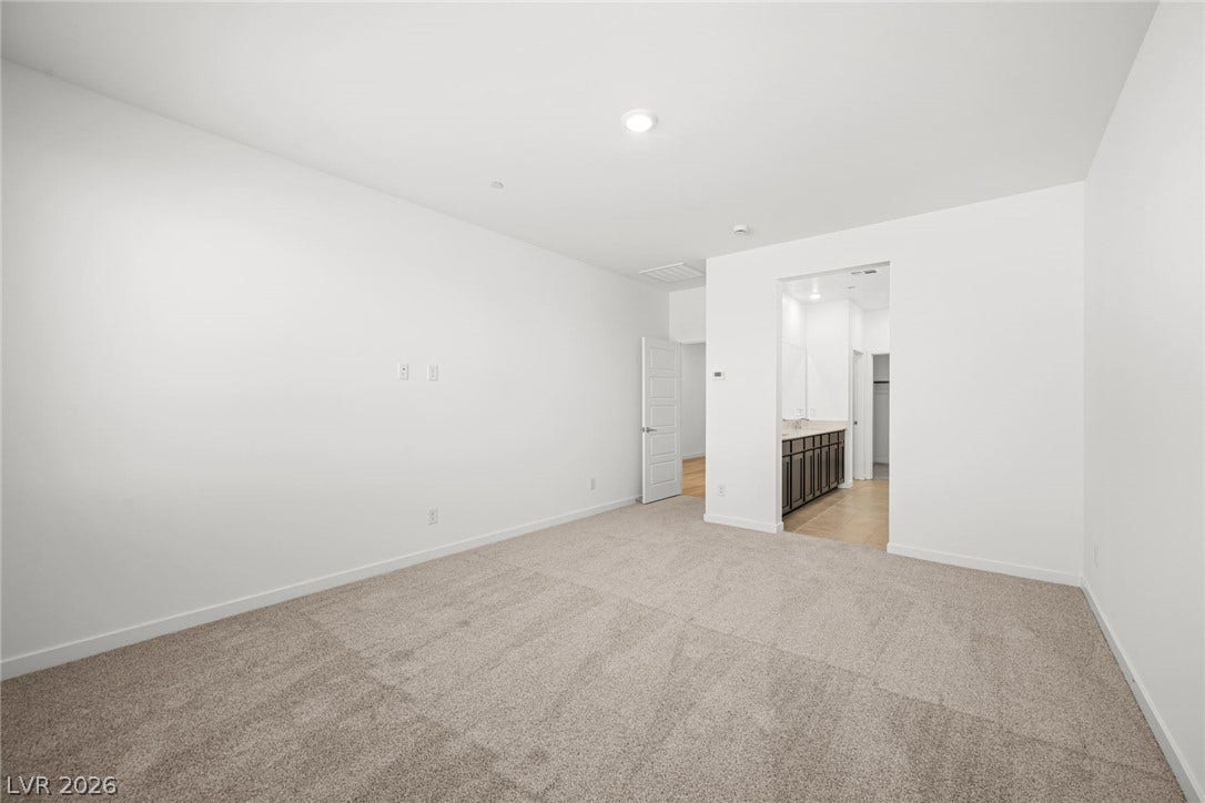 1663 Capri Falls Court, Henderson, NV 89011 Plush carpeting anchors this spacious bedroom featuring direct access to an en-suite bath.