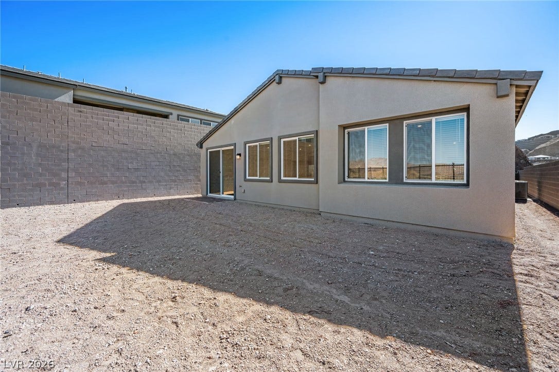 1663 Capri Falls Court, Henderson, NV 89011 An expansive gravel yard ready for customization wraps around the stucco exterior.