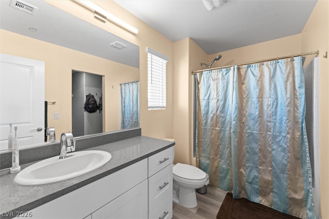 10059 Dazzling Sunrays Avenue, Las Vegas, NV 89129 Smooth solid-surface countertops pair with clean white cabinetry in this functional bathroom.