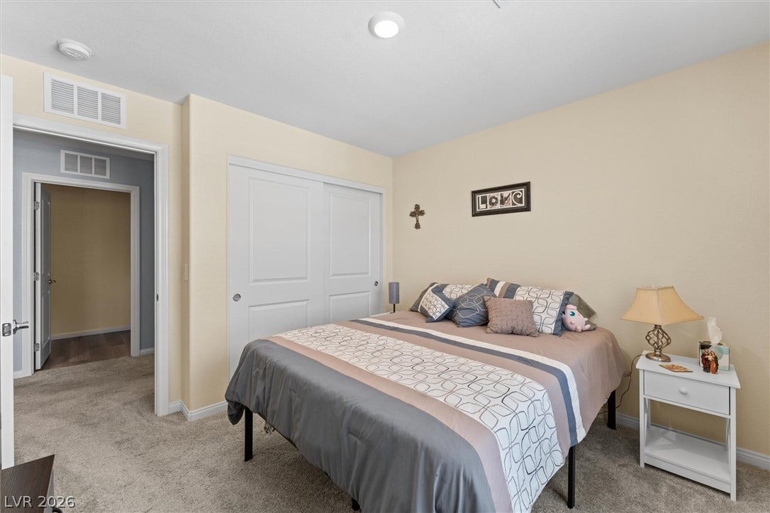 10059 Dazzling Sunrays Avenue, Las Vegas, NV 89129 Soft carpeting pairs with neat trim and sliding closet doors in this comfortable room.