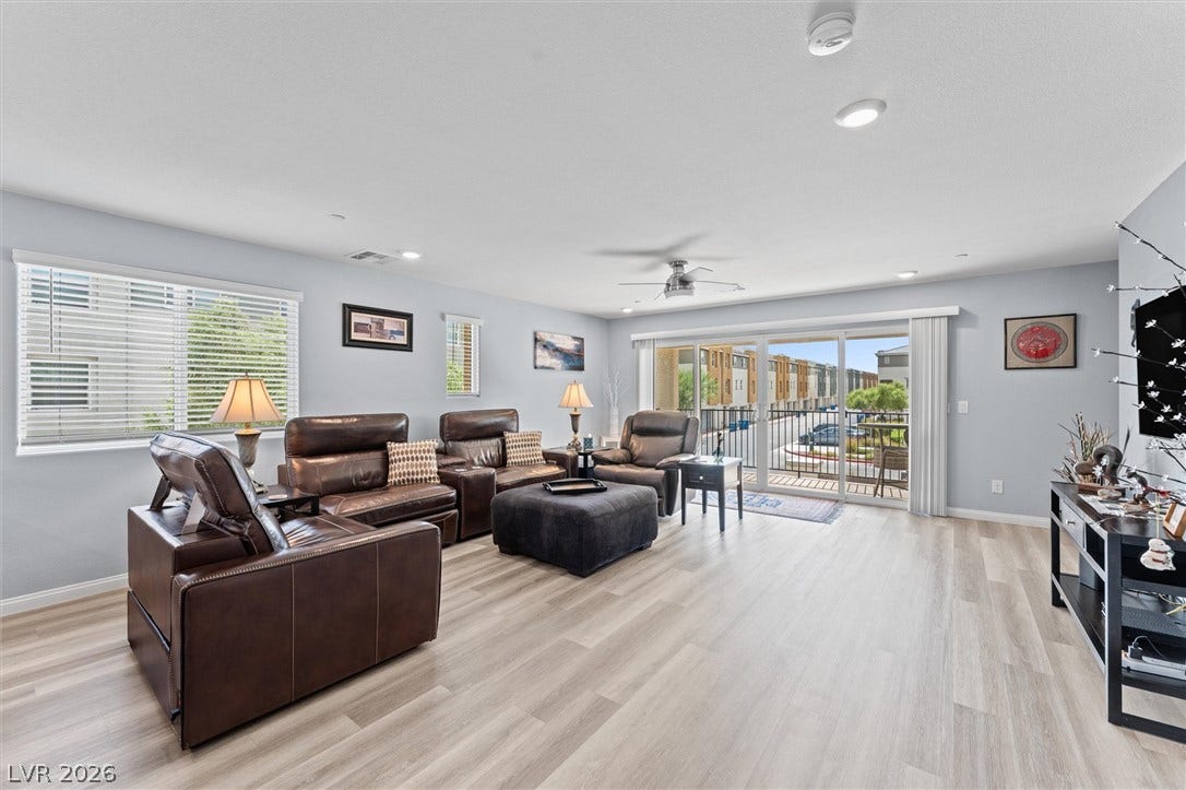 10059 Dazzling Sunrays Avenue, Las Vegas, NV 89129 Sliding glass doors open to a private balcony in this airy living area.
