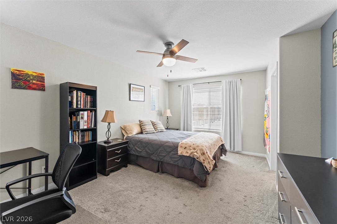 10059 Dazzling Sunrays Avenue, Las Vegas, NV 89129 Natural light fills this comfortable bedroom featuring soft carpeting.