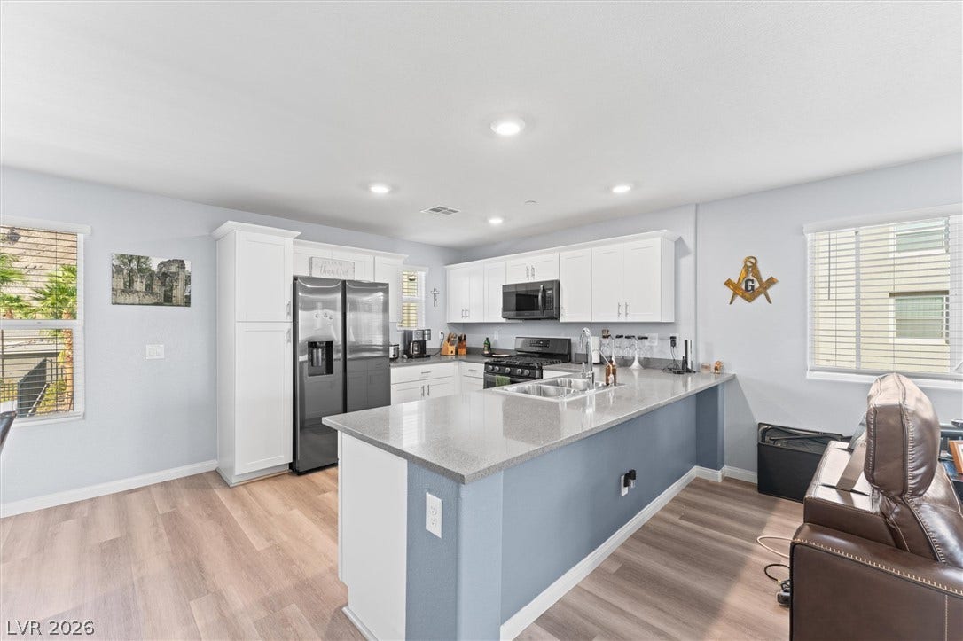 10059 Dazzling Sunrays Avenue, Las Vegas, NV 89129 An open kitchen seamlessly connects modern finishes with a spacious central island and recessed lighting.