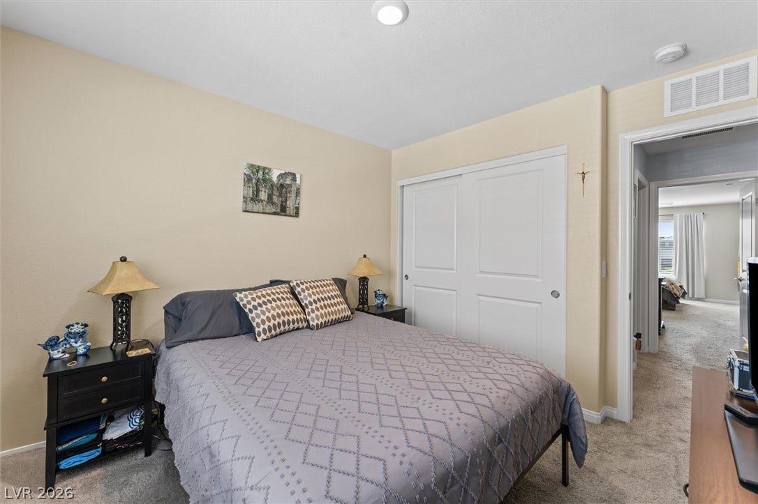 10059 Dazzling Sunrays Avenue, Las Vegas, NV 89129 Plush carpeting anchors this quiet bedroom retreat with built-in sliding closet doors.