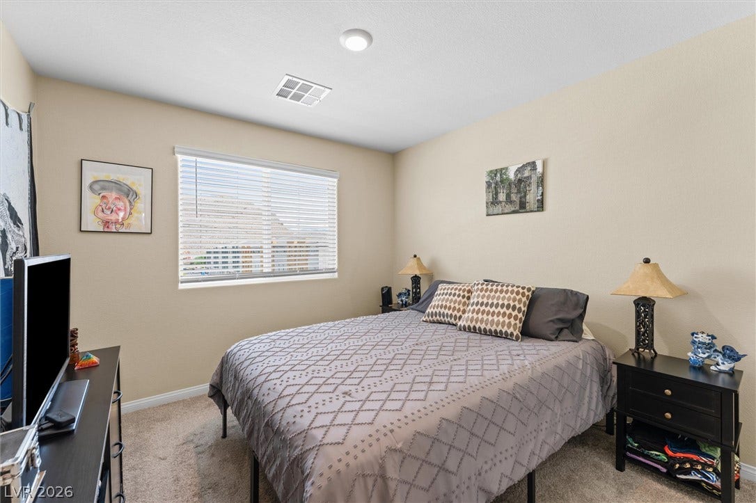 10059 Dazzling Sunrays Avenue, Las Vegas, NV 89129 Plush carpeting and a wide window with integrated horizontal blinds define this comfortable bedroom.