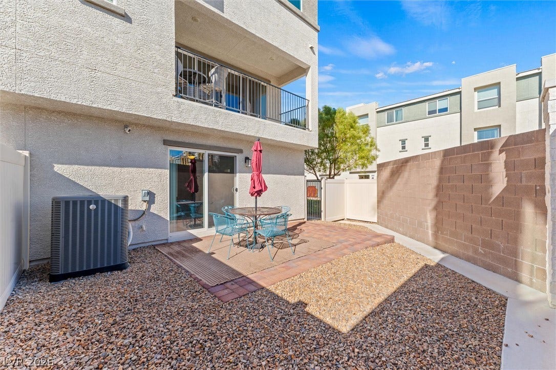 10059 Dazzling Sunrays Avenue, Las Vegas, NV 89129 A private paved patio extends from sliding glass doors within a walled courtyard space.