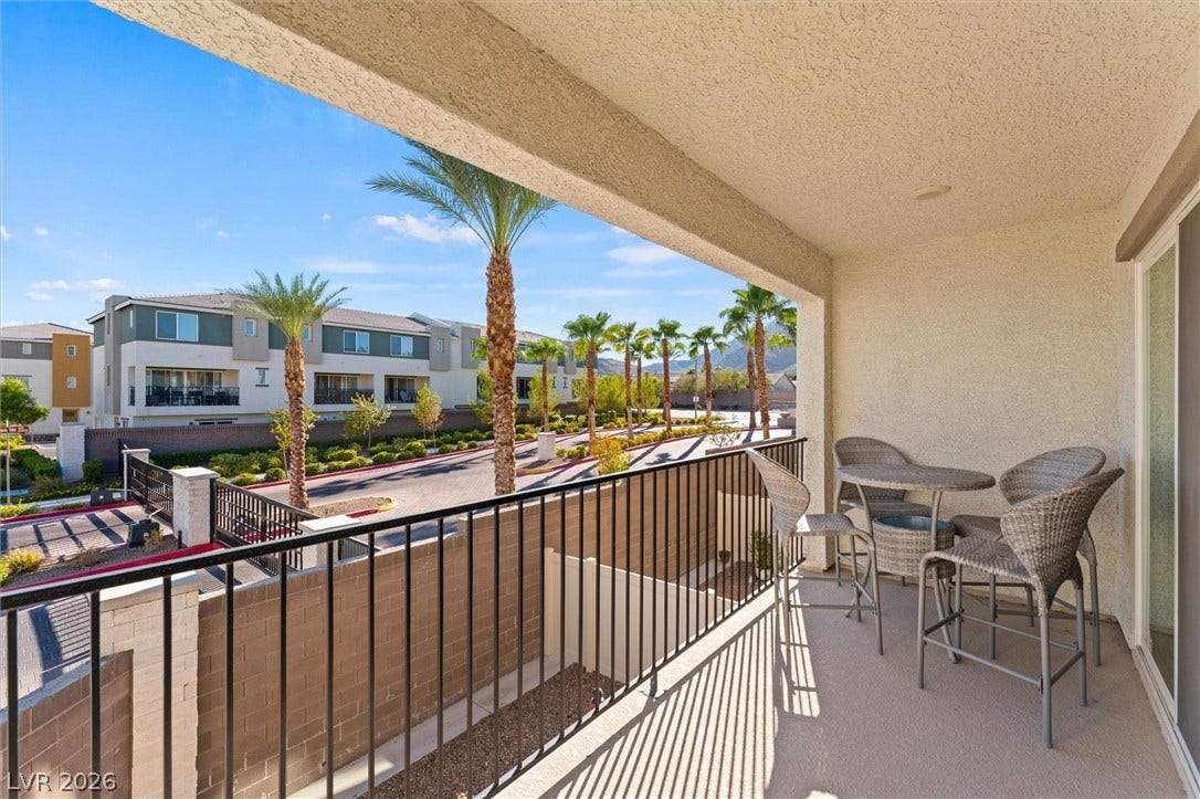 10059 Dazzling Sunrays Avenue, Las Vegas, NV 89129 A private covered balcony overlooks the surrounding neighborhood and palms under clear blue skies.