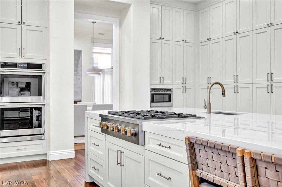8805 Spanish Mountain Drive, Las Vegas, NV 89148 Soaring custom cabinetry and premium appliances define this elegant chef's kitchen with rich hardwood flooring.