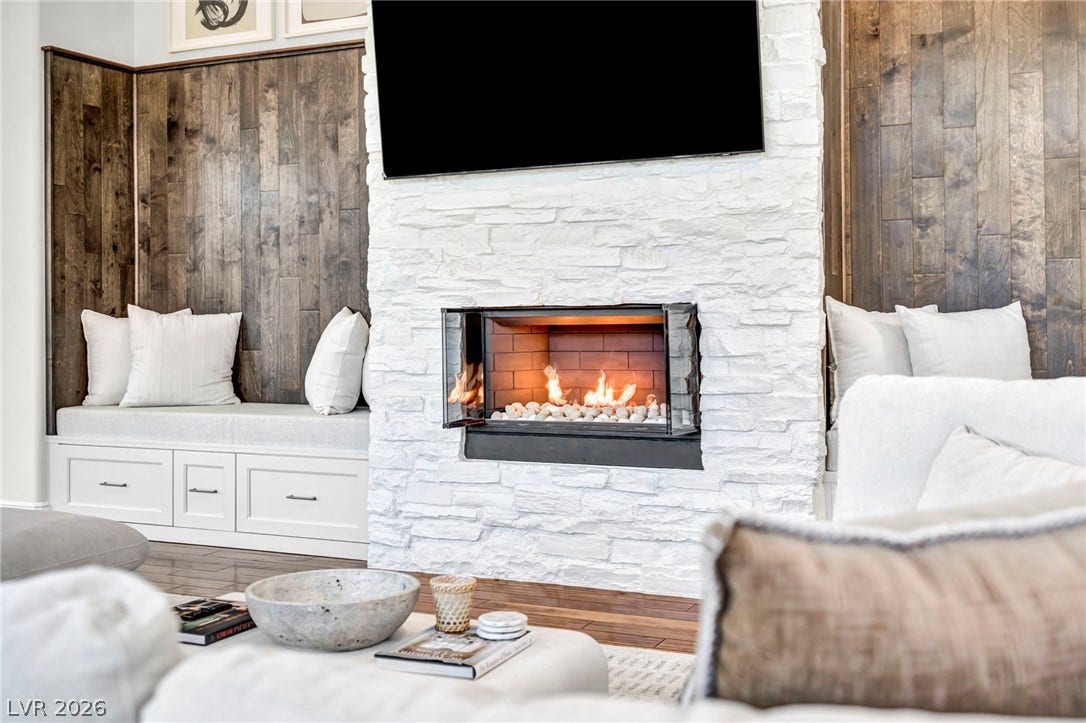 8805 Spanish Mountain Drive, Las Vegas, NV 89148 Rich wood paneling flanks a textured stone fireplace, creating a warm focal point.