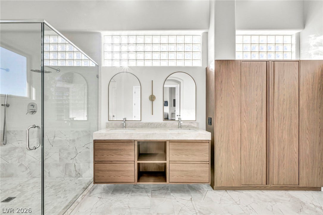 8805 Spanish Mountain Drive, Las Vegas, NV 89148 Fine marble flooring and custom wood cabinetry define this luxurious contemporary bathroom space.