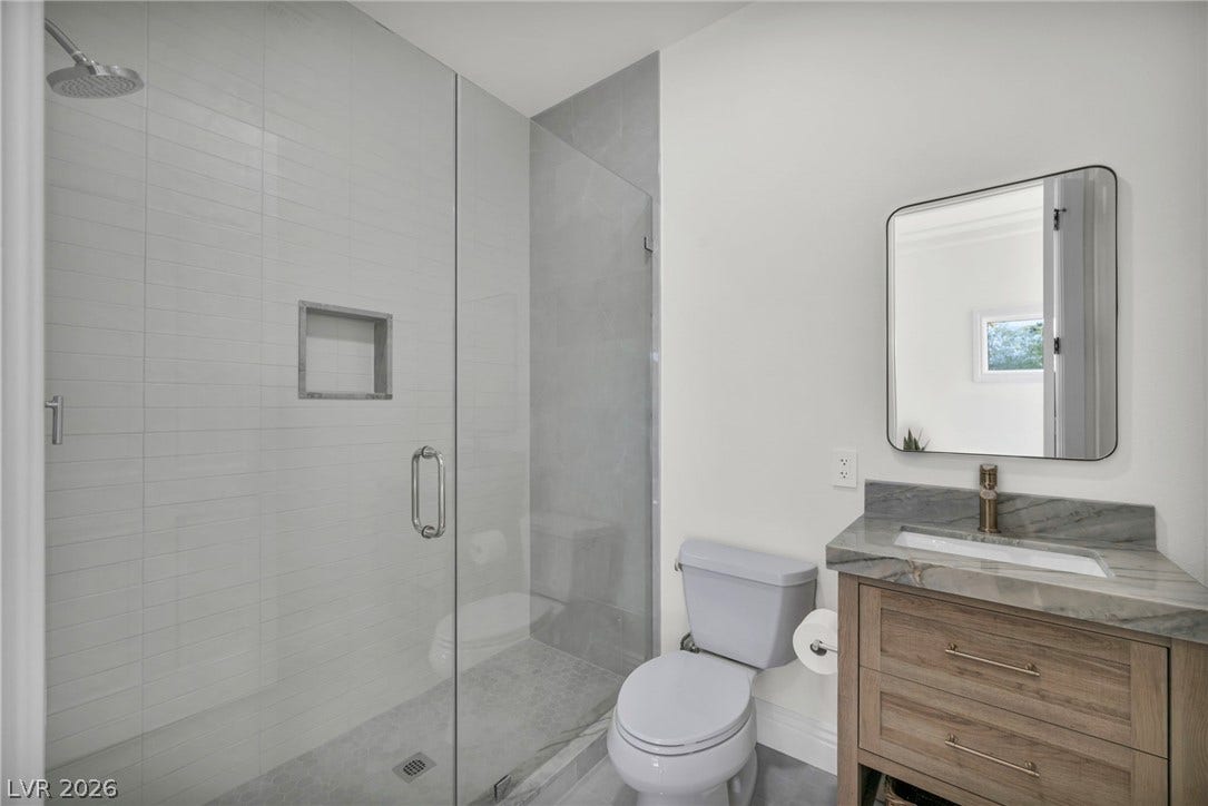 8805 Spanish Mountain Drive, Las Vegas, NV 89148 Clean lines and a walk-in glass shower define this modern bathroom space.