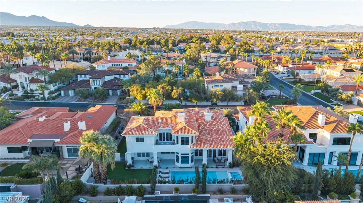 8805 Spanish Mountain Drive, Las Vegas, NV 89148 An aerial perspective showcases a tile-roofed estate complete with a swimming pool and mountain backdrop.