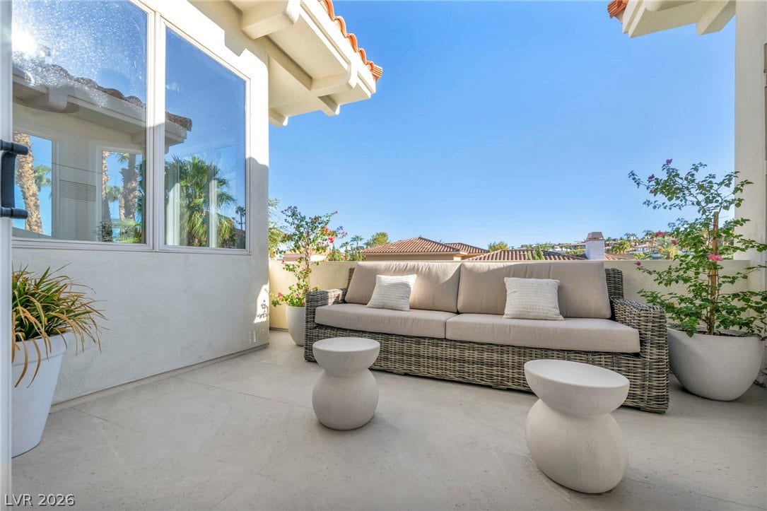 8805 Spanish Mountain Drive, Las Vegas, NV 89148 Clay tile roofing and smooth stucco walls frame this sunny outdoor terrace space.