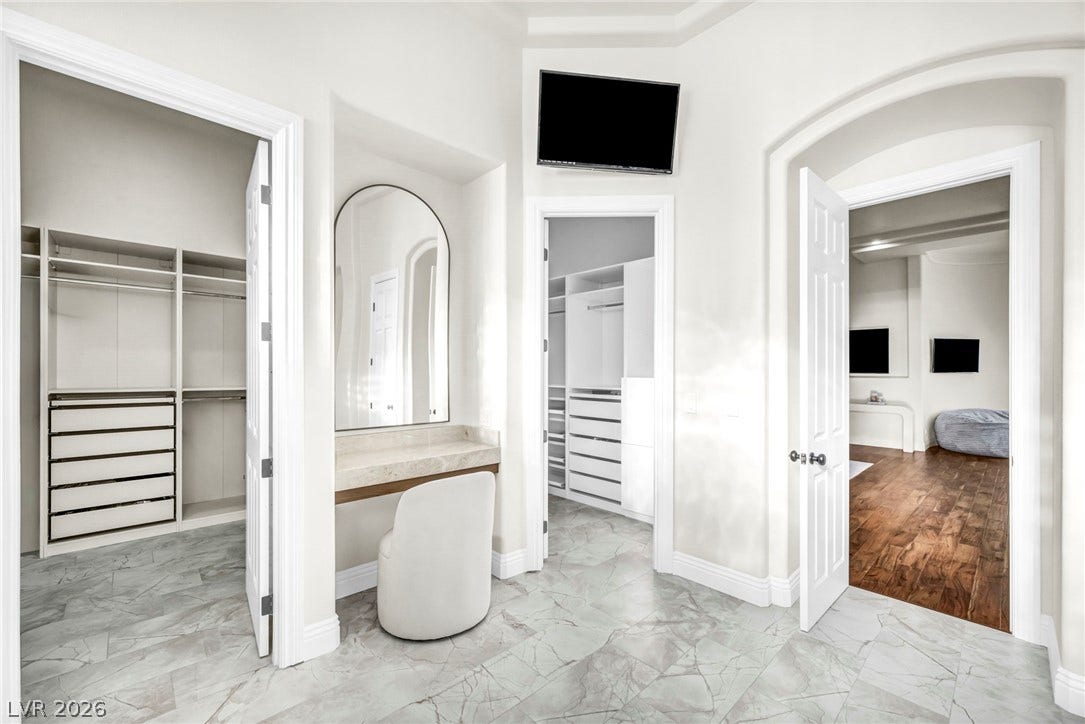 8805 Spanish Mountain Drive, Las Vegas, NV 89148 Gleaming stone tile floors lead past custom built-ins into spacious walk-in closets.