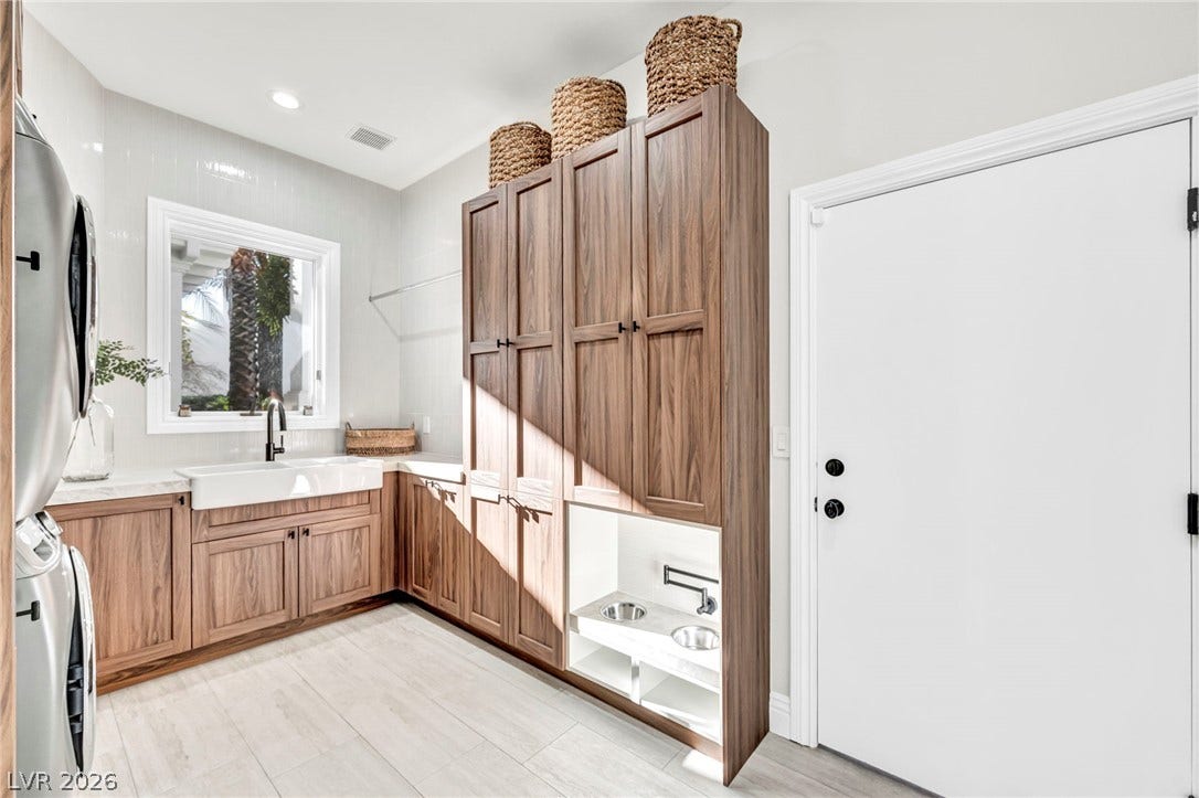 8805 Spanish Mountain Drive, Las Vegas, NV 89148 Rich wood cabinetry and a farmhouse sink anchor this functional utility space.
