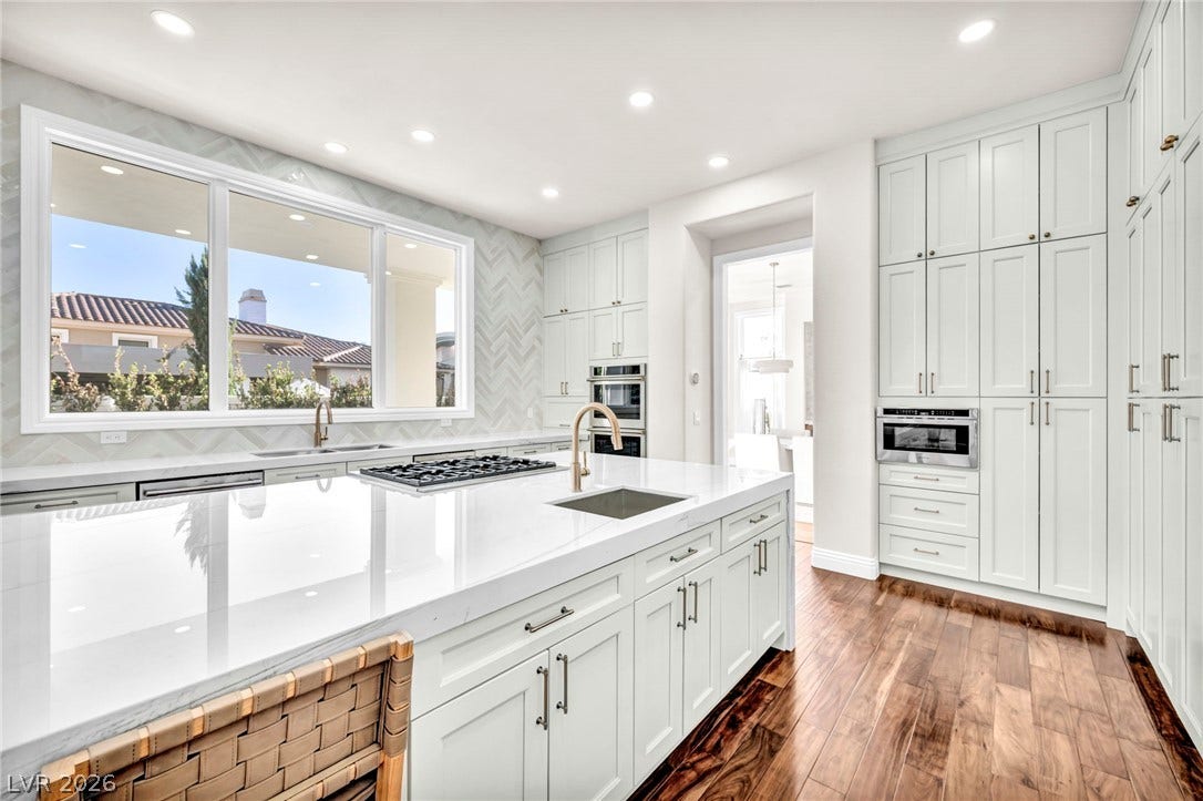 8805 Spanish Mountain Drive, Las Vegas, NV 89148 Rich hardwood flooring complements pristine countertops and abundant cabinetry in this spacious culinary space.