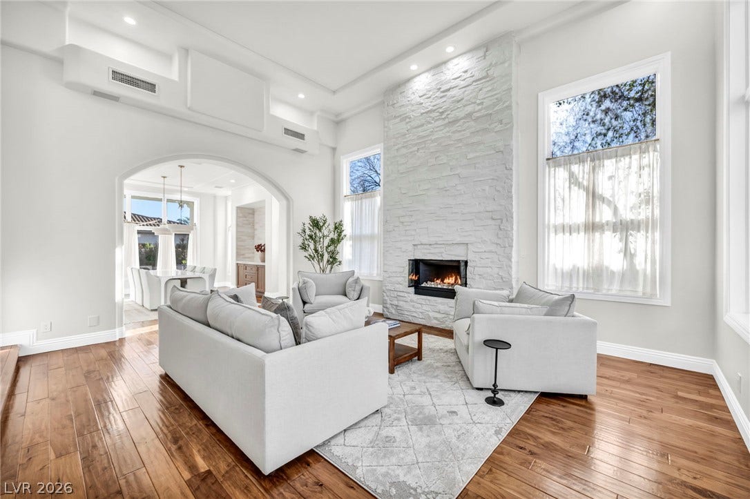 8805 Spanish Mountain Drive, Las Vegas, NV 89148 Gleaming hardwood floors and a towering stone fireplace define this light-filled living room.