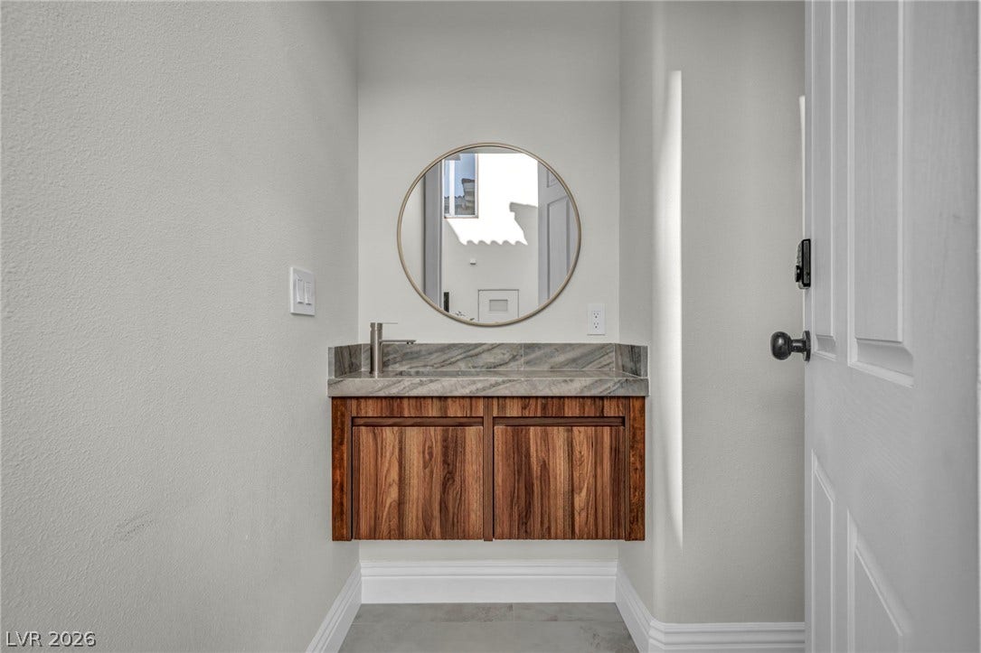 8805 Spanish Mountain Drive, Las Vegas, NV 89148 Rich wood tones and sleek stone countertops define this elegant floating vanity niche.