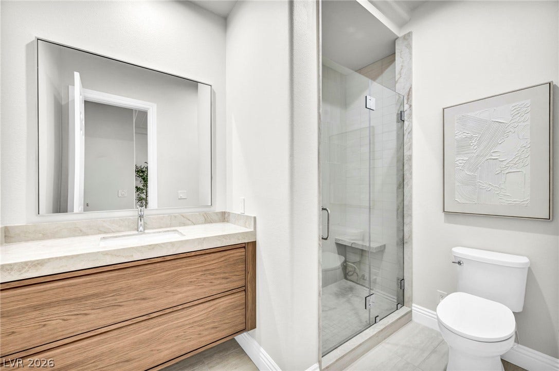 8805 Spanish Mountain Drive, Las Vegas, NV 89148 Clean lines and a glass-enclosed walk-in shower define this modern bathroom space.