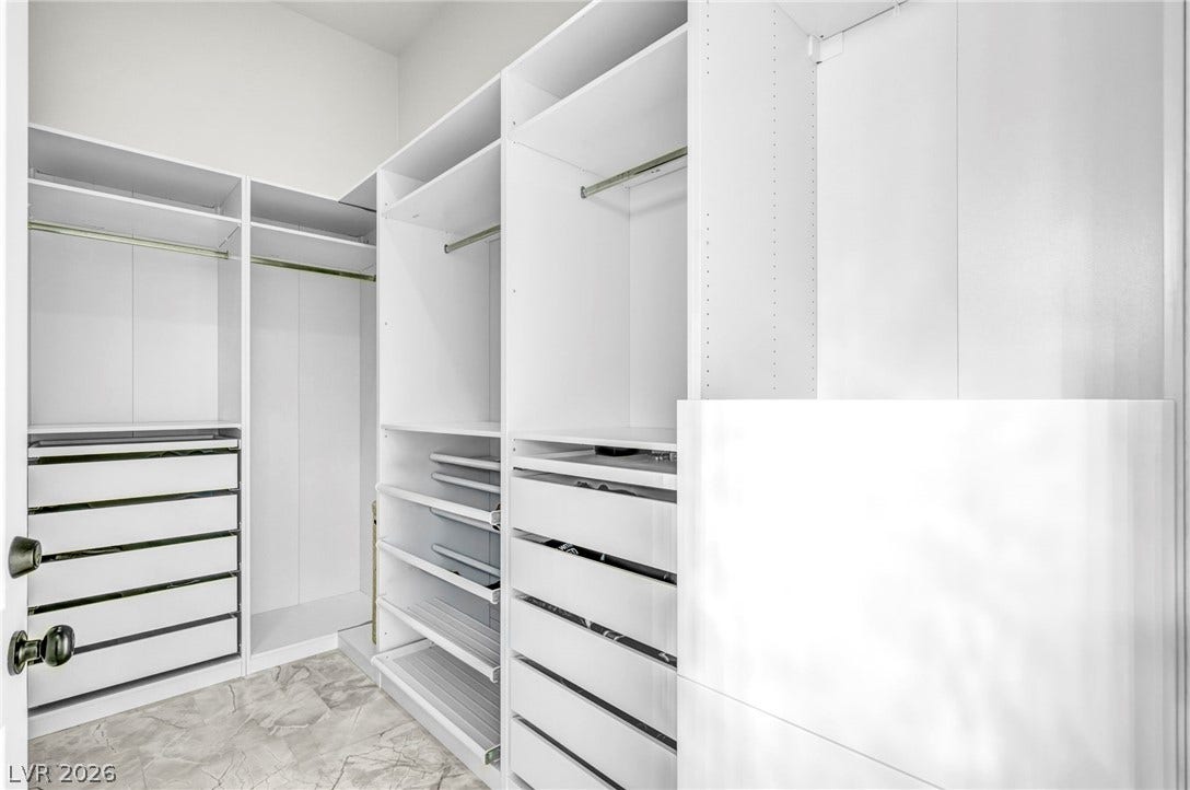 8805 Spanish Mountain Drive, Las Vegas, NV 89148 Custom shelving and hanging rods maximize organization in a spacious walk-in closet.