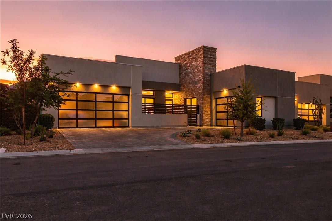 Modern desert architecture commands attention with clean lines and stone accents under a dramatic sunset sky.