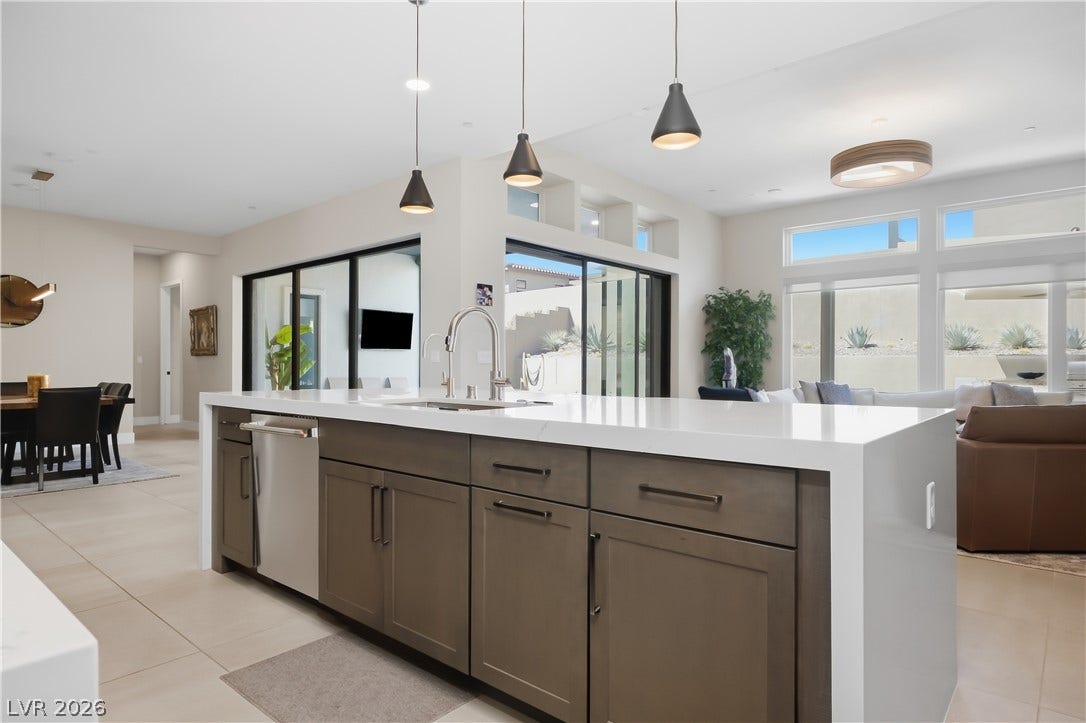 Smooth tile flooring and a waterfall island anchor this open-concept layout.