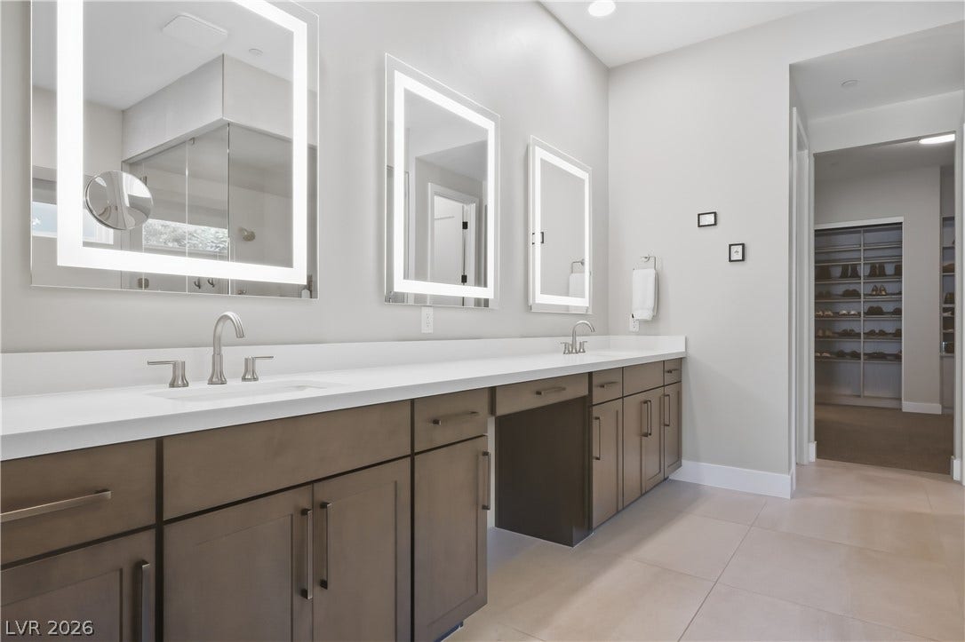 A long dual vanity with sleek countertops highlights this modern bathroom.